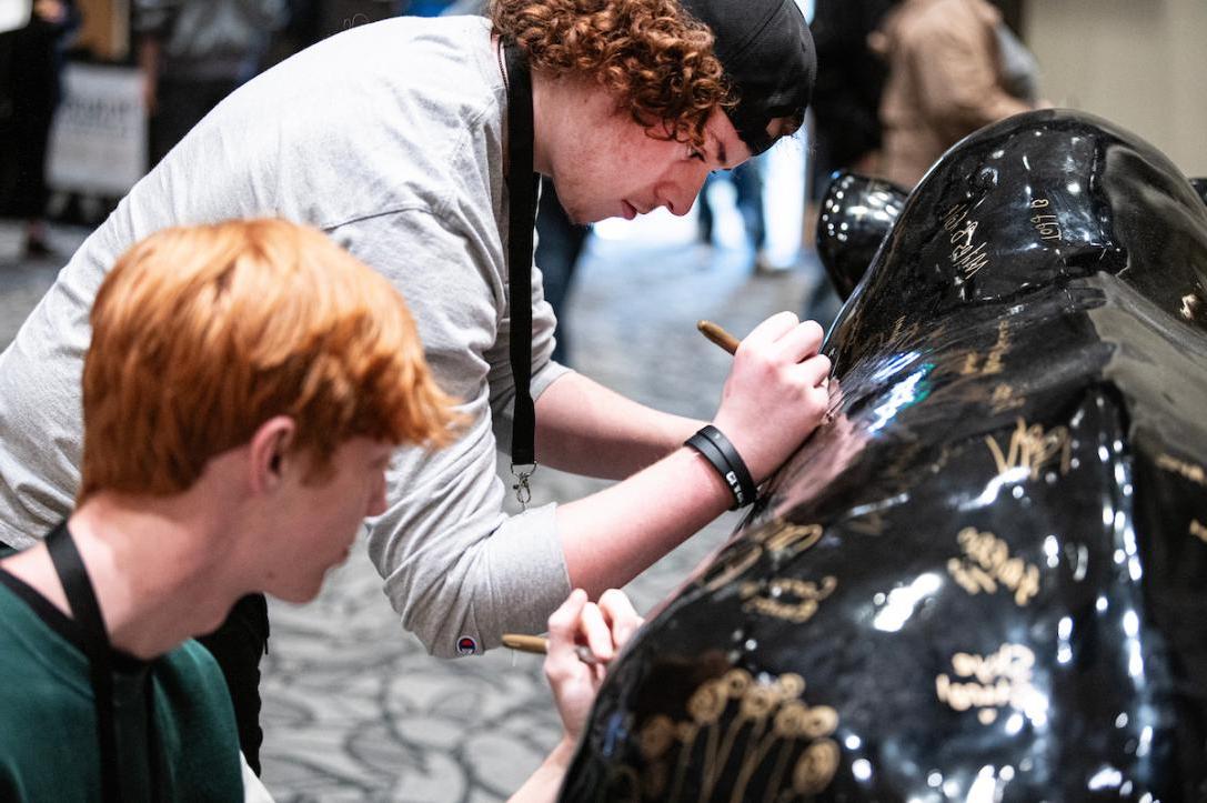 New students sign the Mastodon on Admitted Student Day.