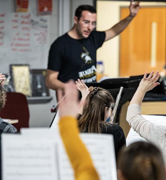 Senior music education student Ethan Hacker conducts the Fusion Band.